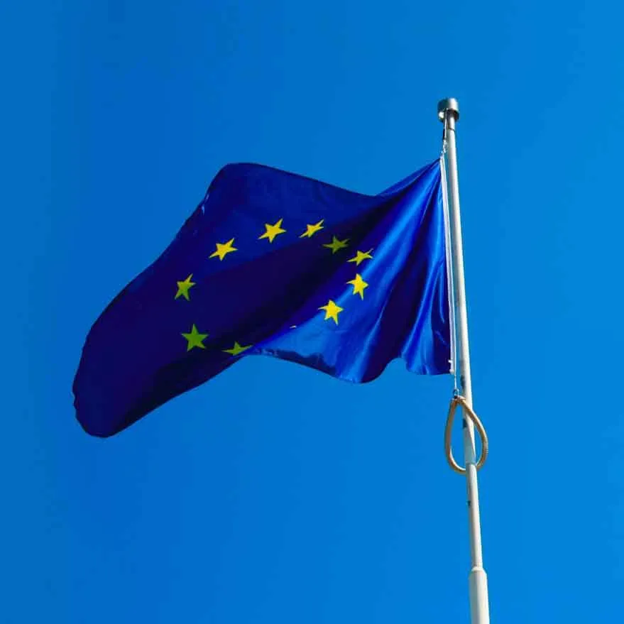 La bandiera dell'Unione europea sventola su un pennone contro il cielo