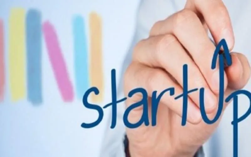 Una mano disegna la parola «startup» con la lettera P prolungata in una freccia verso l’alto